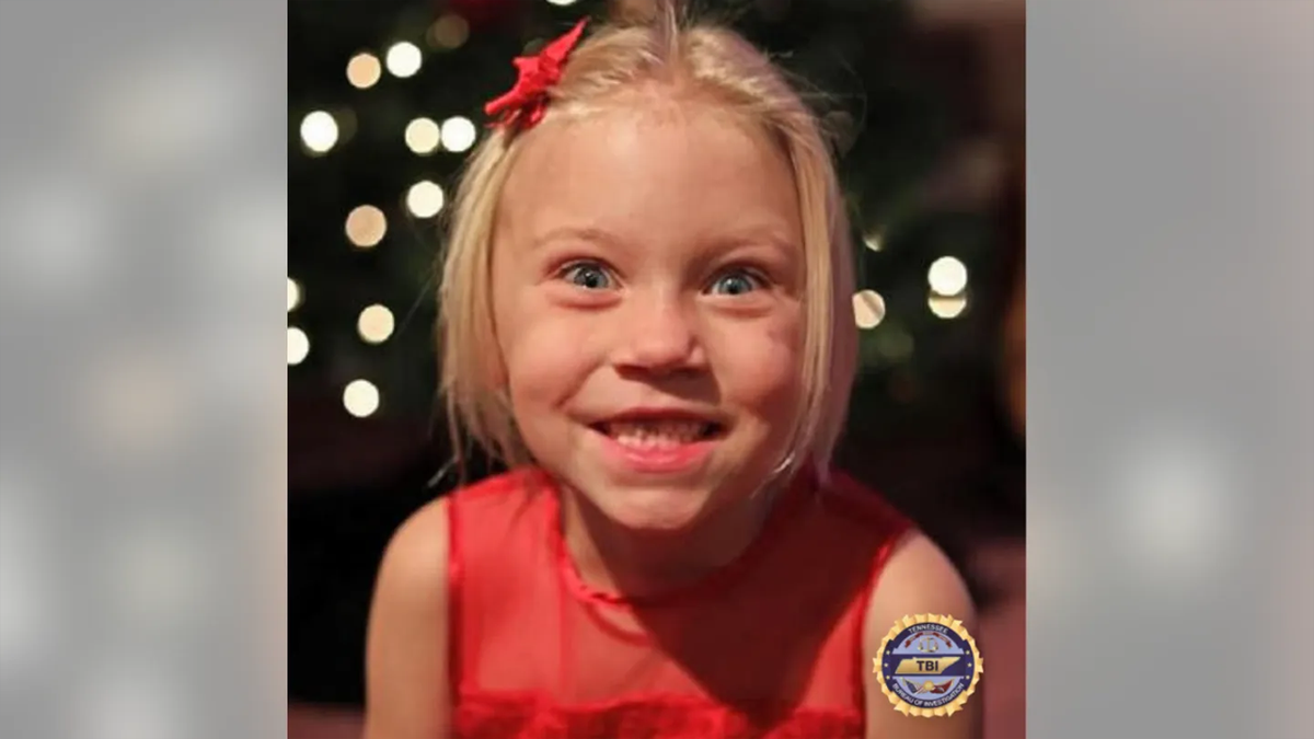 Summer Wells in a red dress with a red bow in her blonde hair