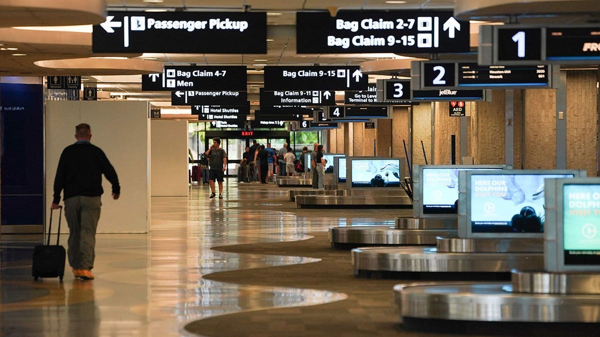 A man walks through baggage claim at Tampa International Airport