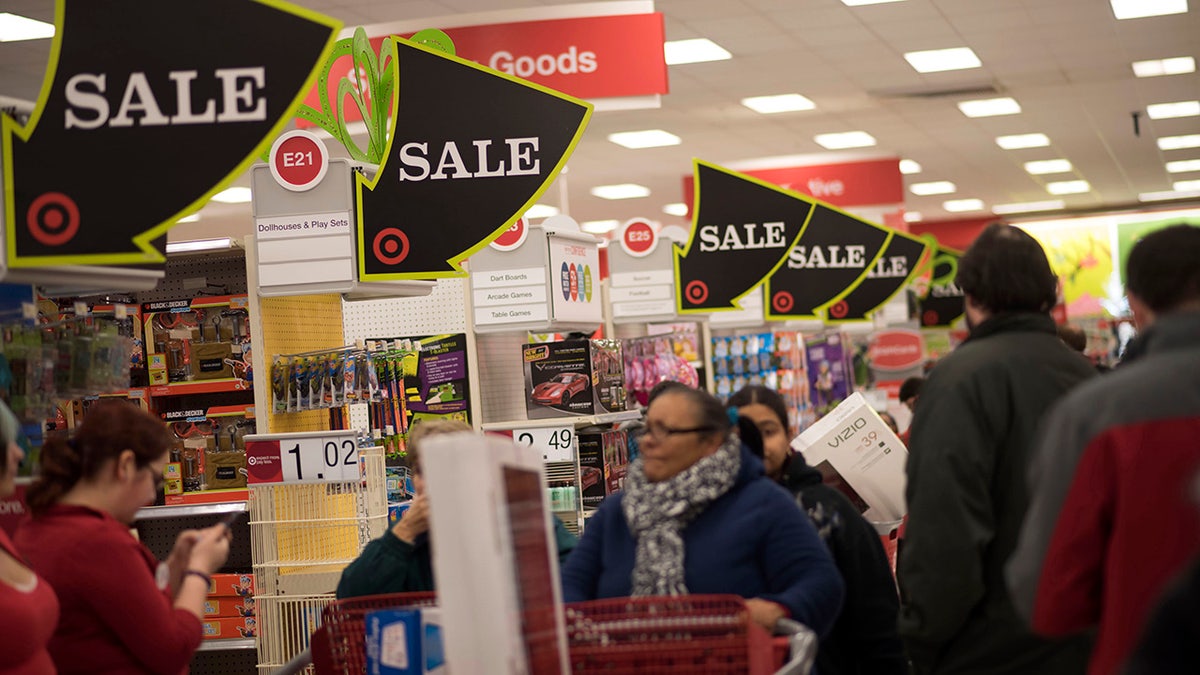 Sale signs hang above shoppers at a Target Corp. store ahead of Black Friday in Mentor, Ohio, U.S., on Thursday, Nov. 27, 2014.