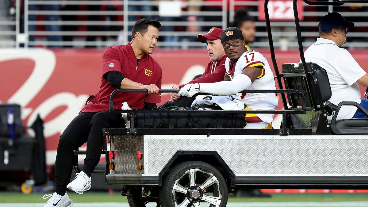 Terry McLaurin is carted off the field during an NFL game.