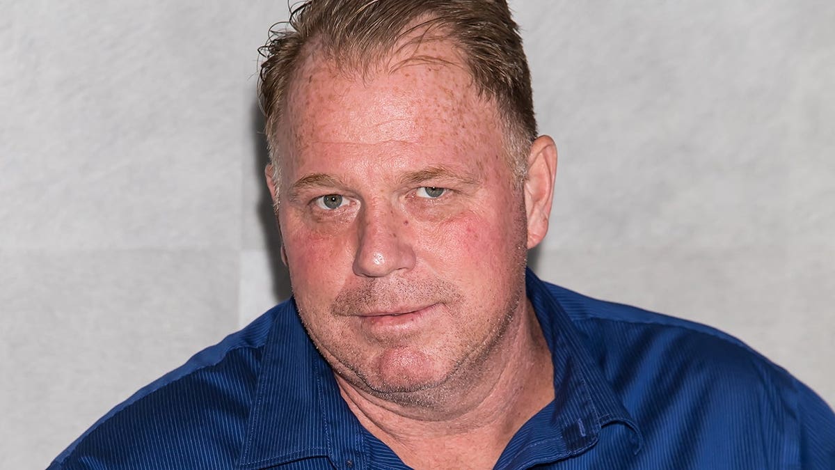 Thomas Markle Jr. stands at a podium during a press conference.