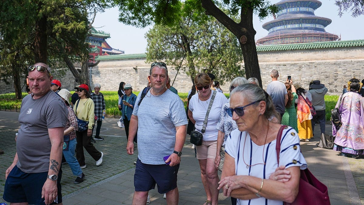 Foreign tourists walk at Temple of Heaven Park in Beijing.