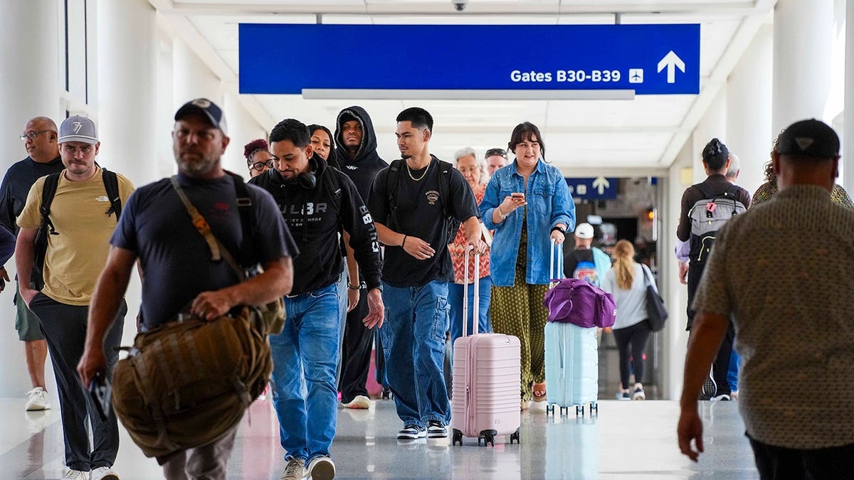 Travelers walk between terminals at DFW Airport in Dallas.