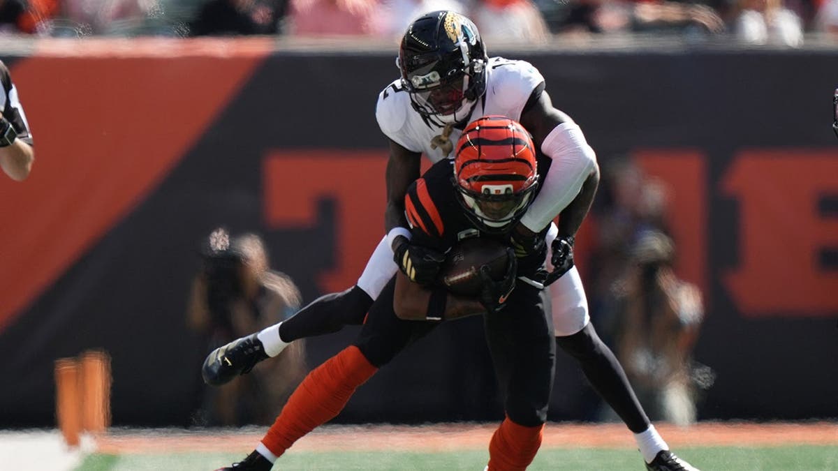 Travis Hunter tackles Ja'marr Chase during an NFL game in Cincinnati.