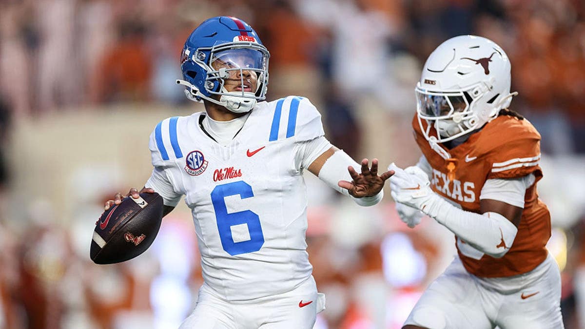 Trinidad Chambliss #6 of Ole Miss looks to pass under pressure from Texas defenders.