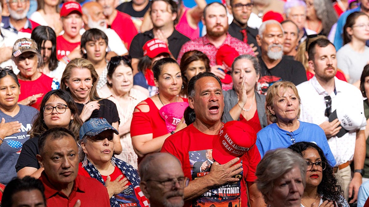 People recite the Pledge of Allegiance at Freeman Coliseum in San Antonio.