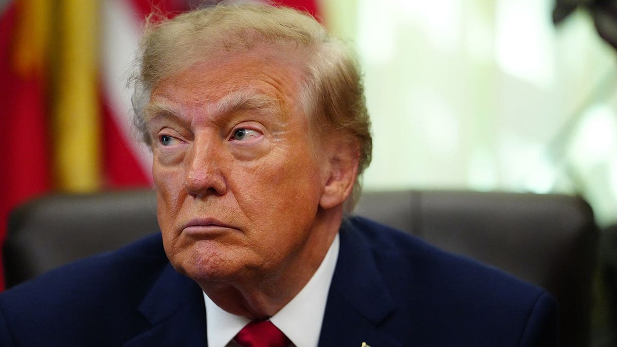 President Donald Trump speaks at a podium in the Oval Office.