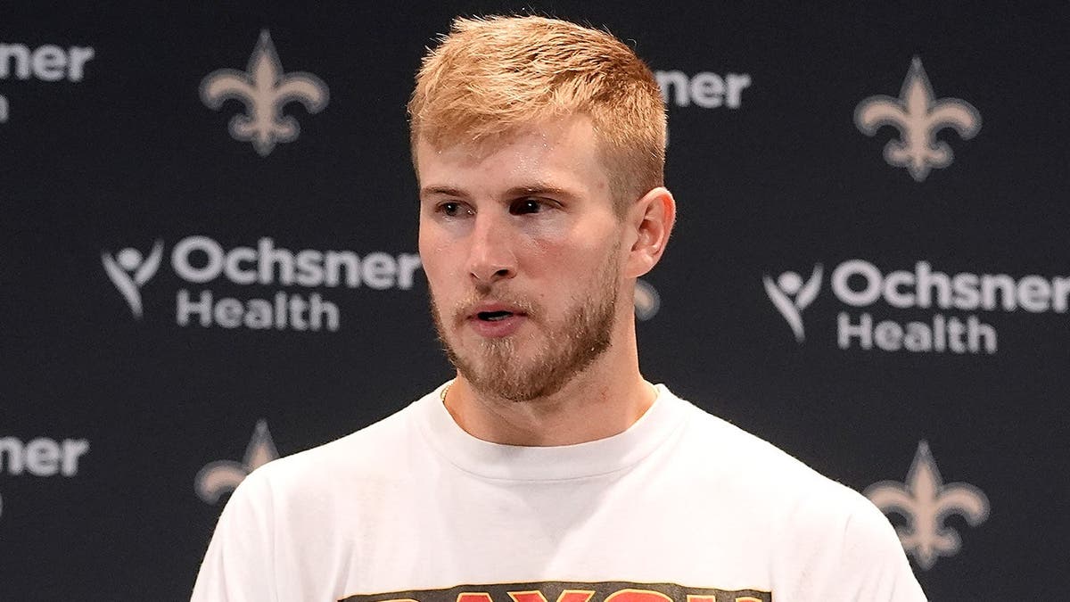 Tyler Shough speaks at a news conference after an NFL game.