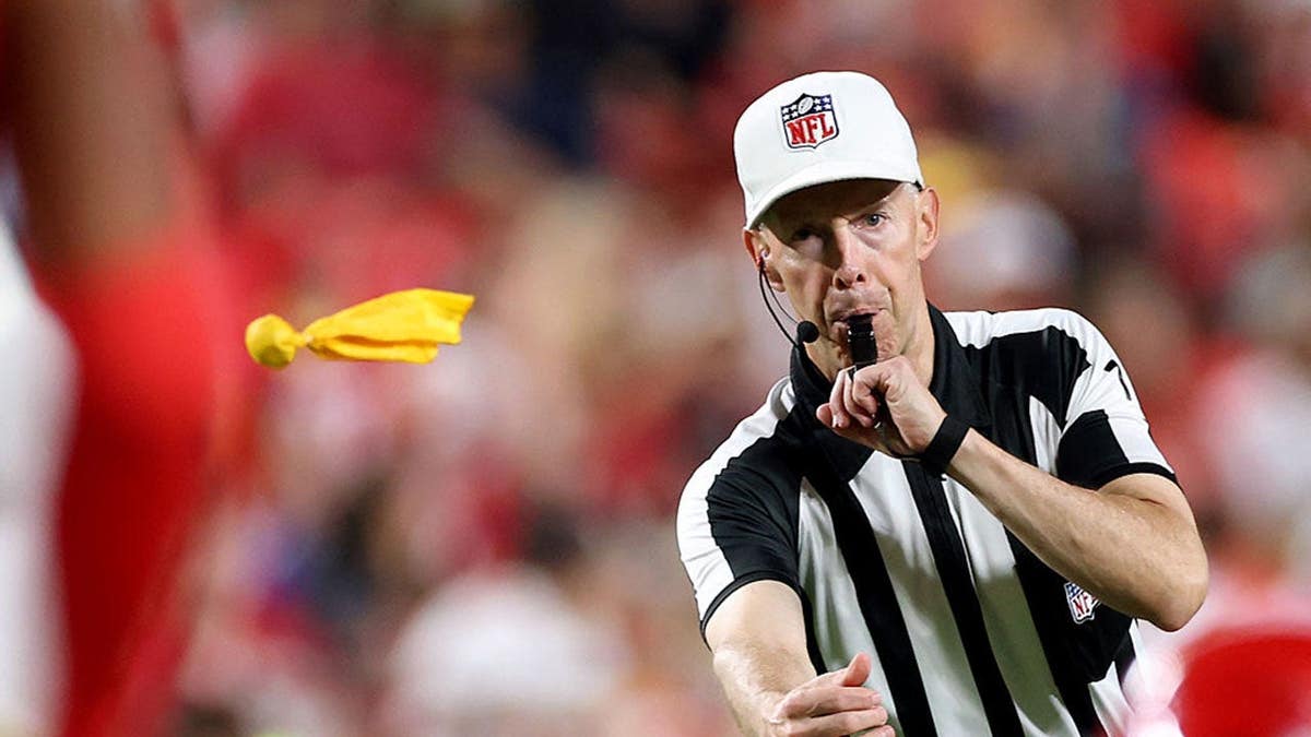 Umpire Mike Morton throws a penalty flag during a preseason game.