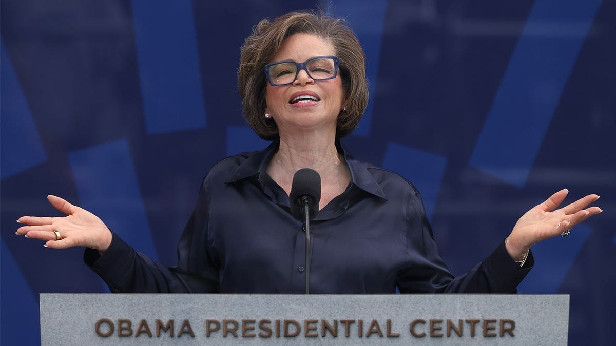 Valerie Jarrett speaks behind an Obama Presidential Center podium with her arms extended during the dedication ceremony in Chicago.