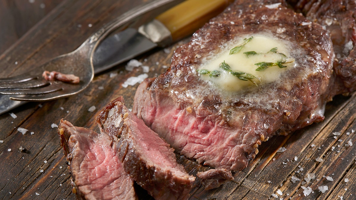 Deer meat, or venison, next to a fork.