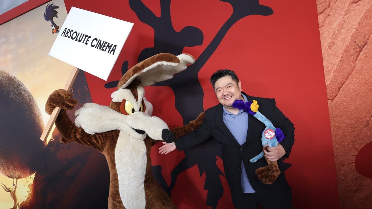 Wile E. Coyote and Eric Bauza stand together at a premiere event in Los Angeles.