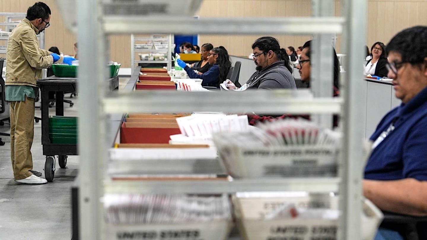 election workers process mail-in ballots