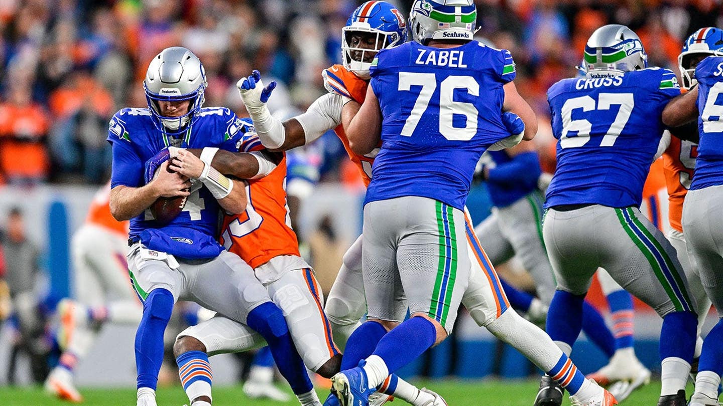 Sam Darnold sendo derrubado pela defesa dos Broncos (Foto: Icon Sportswire via Getty Images)