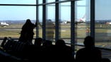 Travelers looking outside at Sydney runway