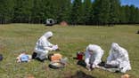Workers in protective uniforms conduct testing in Russia amid heightened precautions