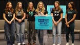 Female athletes gather on stage