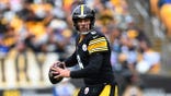 Aaron Rodgers looks to pass during a game at Acrisure Stadium.