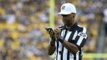 NFL referee Adrian Hill makes a note during the Seahawks-Steelers game at Acrisure Stadium.