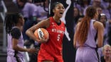 Angel Reese #5 reacts between Tiffany Hayes and Kiah Stokes during WNBA Finals game two.