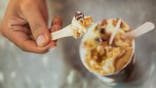 Adult men eating rum raisin ice cream.