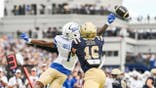 David Wells Jr. tips a pass in front of Giuseppe Sessi during a football game at Navy-Marine Corps Memorial Stadium.
