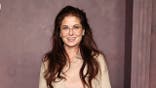 Debra Messing smiling at a premiere event in New York City.