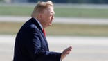 President Donald Trump gestures while walking to board Air Force One at Joint Base Andrews.
