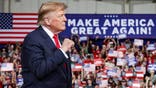 Donald Trump speaks at a podium on stage during a rally in Perry, Georgia.