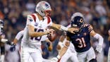 Drake Maye #10 of the New England Patriots scrambles during a game at Soldier Field.