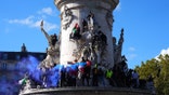 Protesters climb onto the Monument à la République