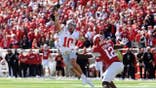 Julian Sayin #10 looks to throw over Tobi Osunsanmi #12 during a football game.