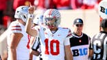 Julian Sayin signals a first down during a college football game.