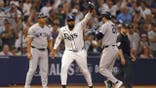 Junior Caminero celebrates after tagging out Austin Wells at third base during a Rays-Yankees playoff game.