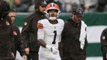 KC Concepcion of the Cleveland Browns walks off the field with medical staff during a game.