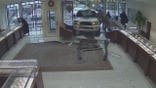 Masked suspects rush through an opening, one carrying an axe.