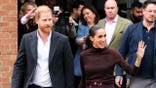 Prince Harry and Meghan Markle are walking outside together in Nottingham.