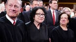 Chief Justice John Roberts and Associate Justices Sonia Sotomayor, Elena Kagan, Neil Gorsuch, Brett Kavanaugh and Ketanji Brown Jackson stand in the House Chamber.
