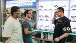 Russian buyer tries on AI smart glasses at Yiwu Global Digital Trade Center in China.