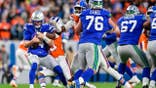 Sam Darnold is sacked during the first quarter of a Broncos-Seahawks game.