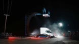The Tesla Roadster jumps over several vehicles.