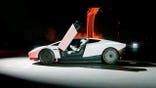 A driver sits in a Tesla Roadster.