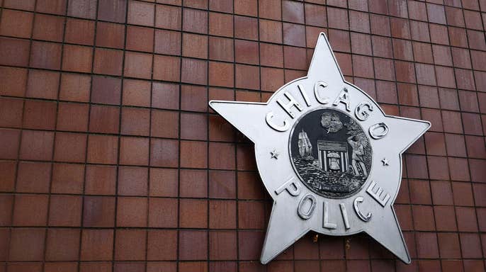 Large silver Chicago Police Department star emblem mounted on a brick exterior wall