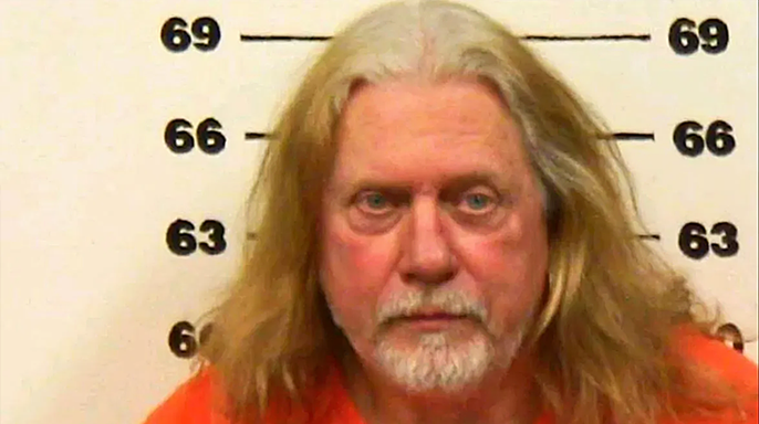 Don Wells mugshot, with long white hair and a short beard