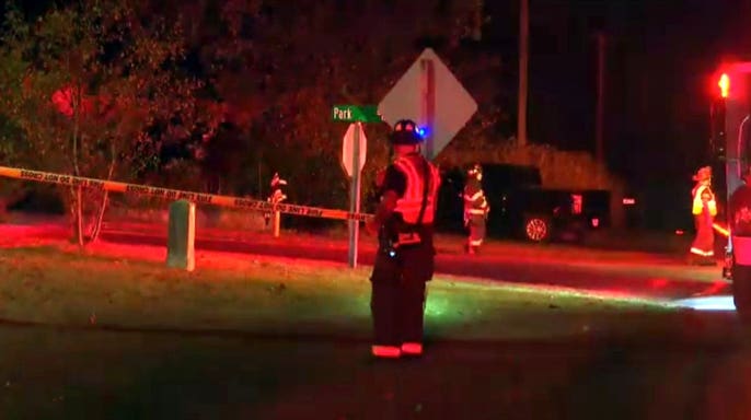 First responders stand at a small plane crash scene in Dellona, Wisconsin.