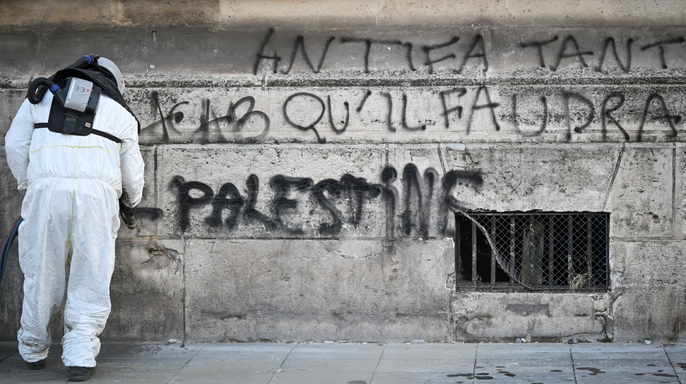 A city employee cleans tags from walls in central Paris, on October 18, 2026 a day after nationwide protests against the "high cost of living".