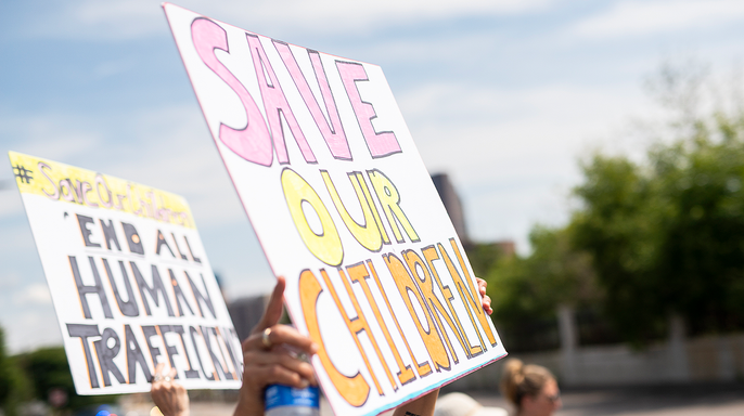People hold signs reading 