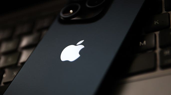 iPhone resting on a MacBook keyboard.