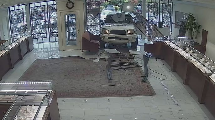 A man points a gun as suspects flee the scene.