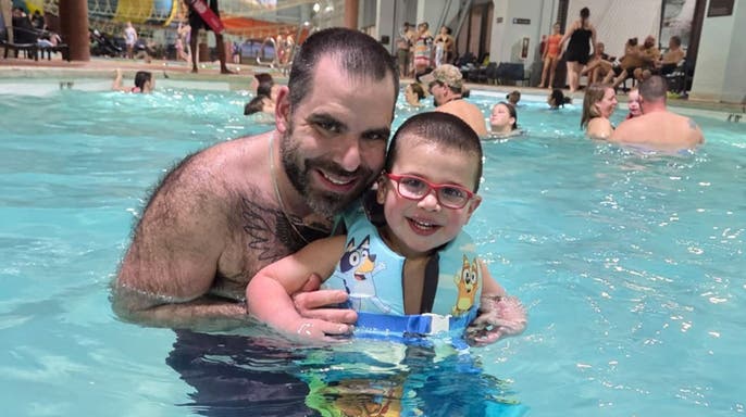 image shows father and son in pool
